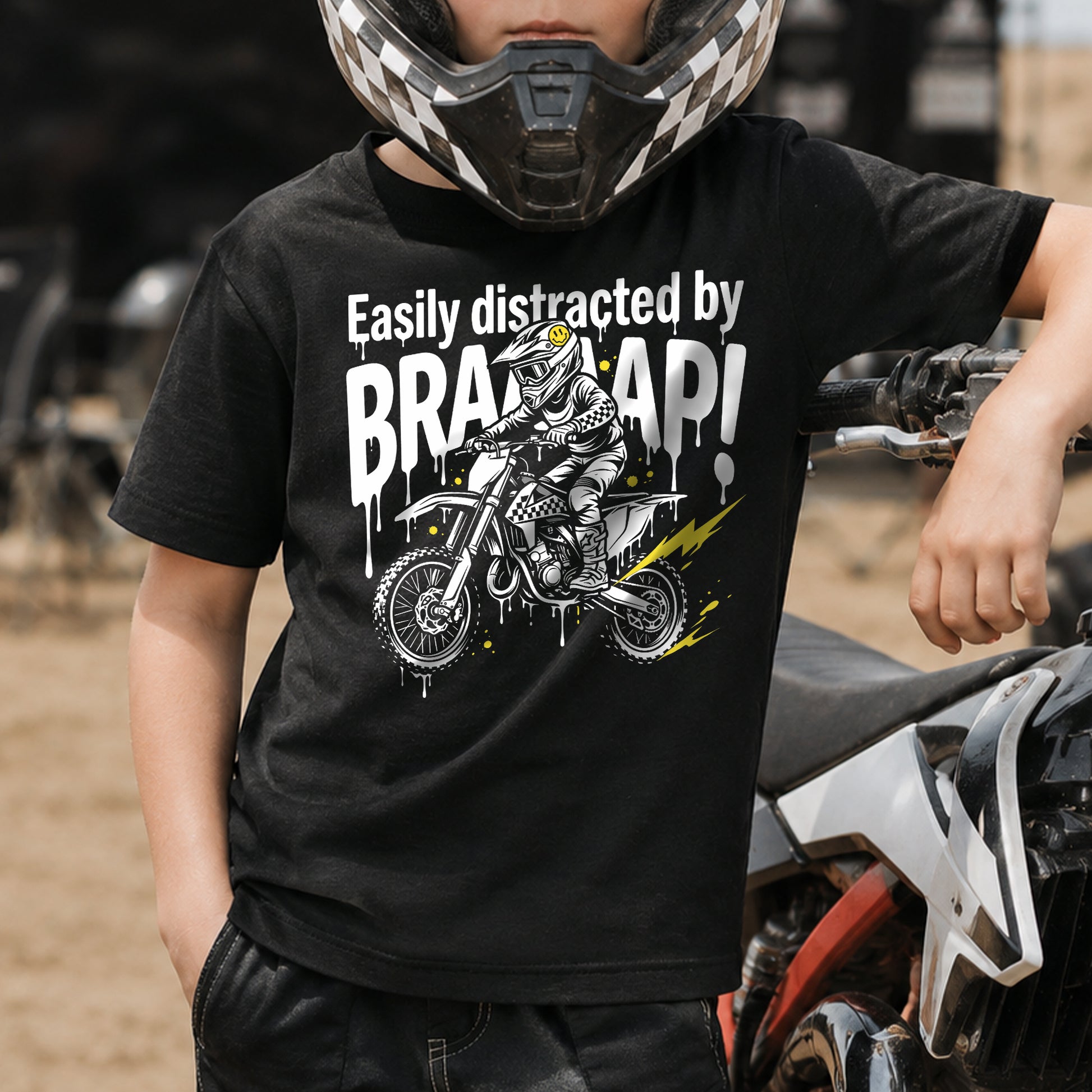 Kid wearing the Easily Distracted by Braaaap dirt bike t-shirt